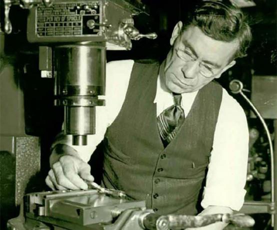 John C. Garand bearbeitet Metall an einer Maschine.