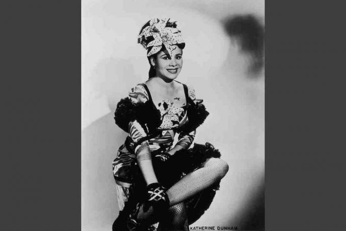 Katherine Dunham um 1945, trägt ein Tanzkostüm mit Rüschenbüscheln und künstlichen Orchideen