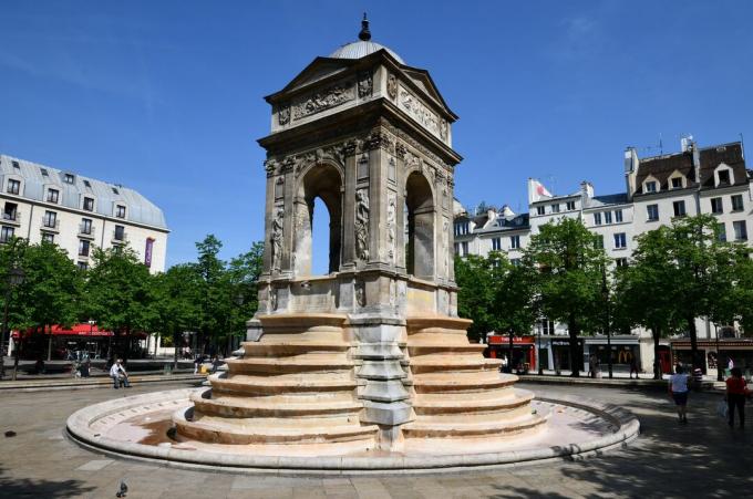 vierseitiges offenes Denkmal mit sechs Stufen auf jeder Seite, die zu einem Brunnen oder einer Glocke führen