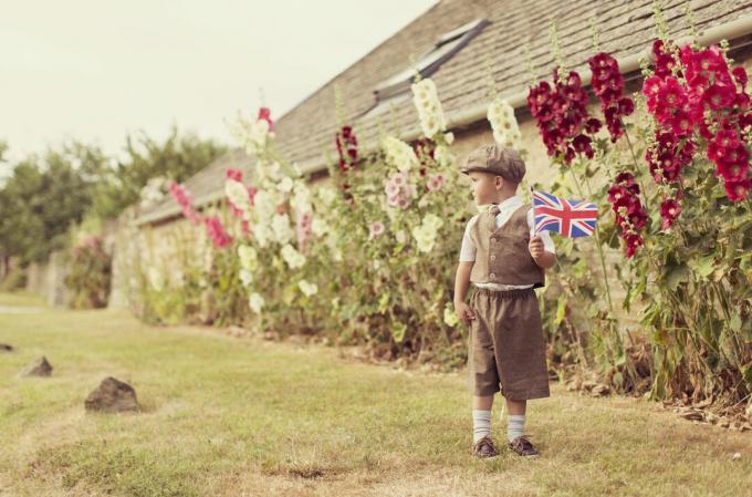 Vintage britischer Junge, der mit Union Jack steht