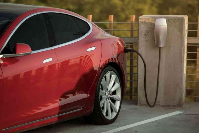 Aufladen des Elektroautos von Tesla Motors im öffentlichen Parkhaus