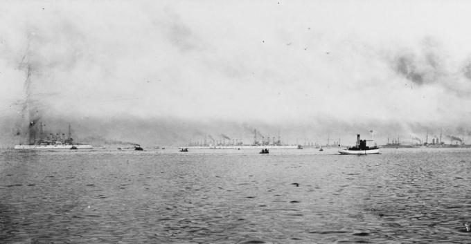 Schlachtschiffe der Großen Weißen Flotte im Hafen mit der japanischen Flotte. Kleines Handwerk im Vordergrund.