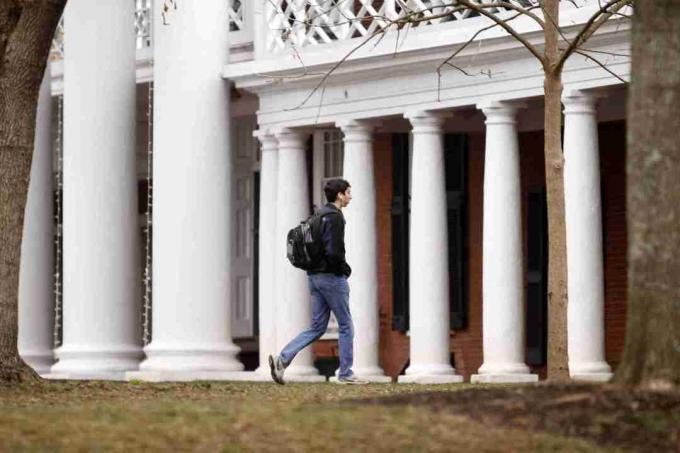 Student geht auf einem College-Campus in der Nähe von toskanischen Säulen