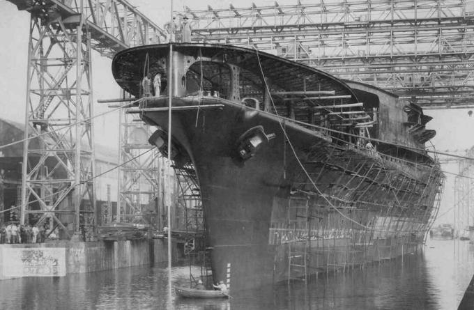 Unvollendeter Rumpf des Trägers Akagi nach seinem Start in der Nähe eines Docks.