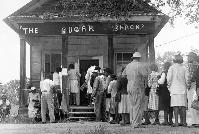Afroamerikanische Wähler, die zum ersten Mal im ländlichen Wilcox County, Alabama, wählen konnten, stellen sich nach der Verabschiedung des Bundeswahlrechtsgesetzes im Jahr 1965 vor einem Wahllokal auf.
