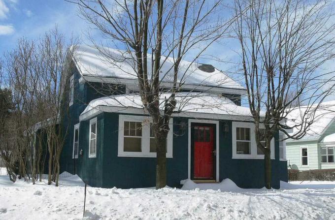 Eine leuchtend rote Tür ist ein traditionelles Merkmal in vielen Häusern. Dieses Landhaus ist in einem satten, fast schwarzen Grauton gestrichen.