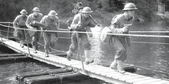 Amerikanische Soldaten überqueren eine kleine Pontonbrücke.