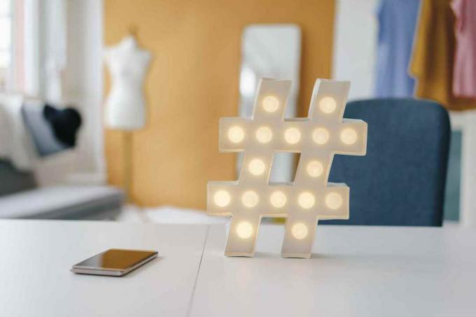 Beleuchtetes Hashtag-Schild auf dem Tisch im Modestudio