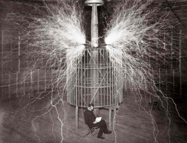 Nikola Tesla sitzt in seinem Labor in Colorado Springs neben seinem riesigen 