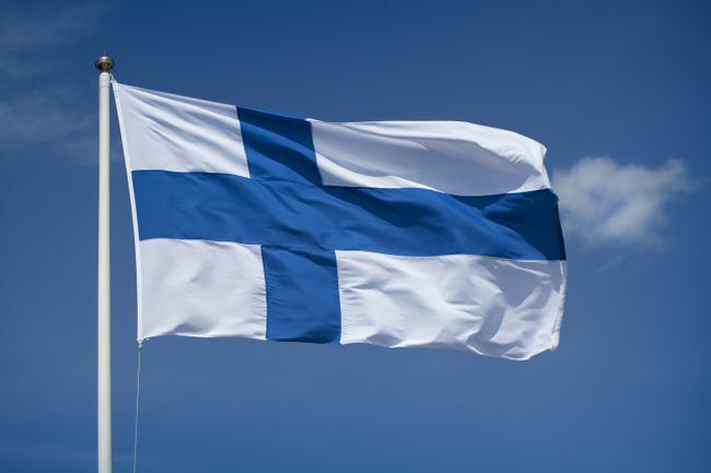 Gehisste finnische Flagge mit blauem Himmelshintergrund