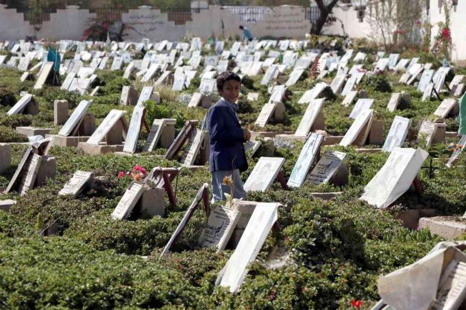 Ein Kind geht zwischen Gräbern von Menschen um, die im andauernden Krieg auf einem Friedhof in Sanaa, Jemen, getötet wurden.