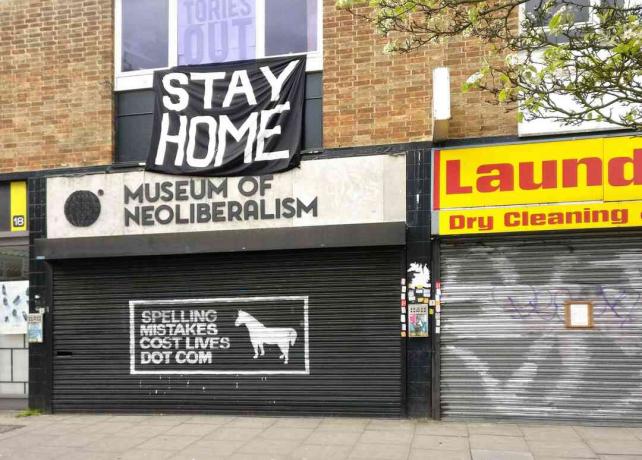 Großes STAY HOME-Schild über dem geschlossenen Museum für Neoliberalismus in Lewsiham, London, England.