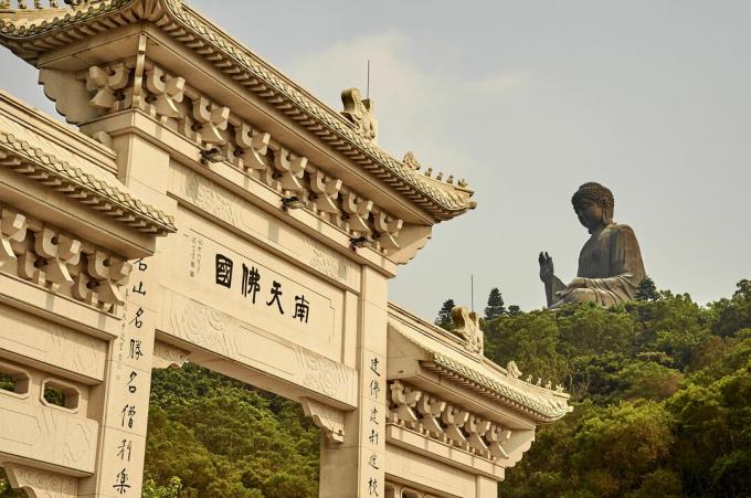 Chinesischer Eingang im Vordergrund und riesige Statue im Hintergrund